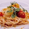 plated pasta with scallops and tomatoes.
